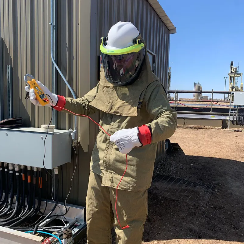 Electrician in arc flash PPE testing equipment